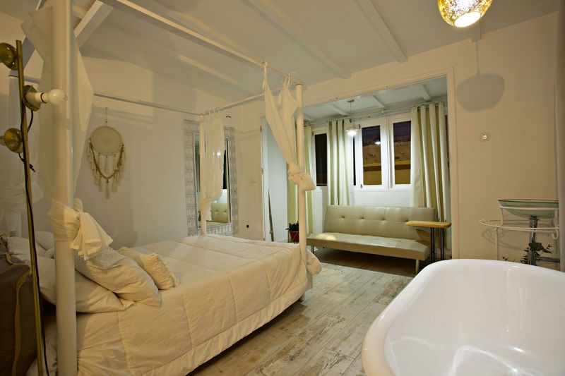 Quarto com cama de dossel e banheira independente junto à cama