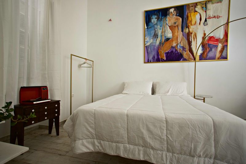 Quarto de paredes quentes com cama, secretária e pintura laranja e azul